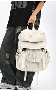 Dettaglio dello zaino in nylon bianco panna con fibbie nere e coulisse laterali regolabili