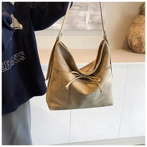 Détail du sac cabas en daim marron clair avec nœud coulissant et poche latérale