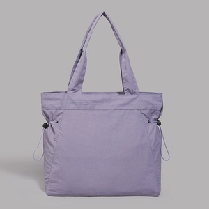 Detail of light purple nylon tote bag featuring adjustable side drawstrings and smooth texture