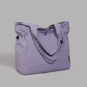 Detail of lavender tote bag featuring side drawstring adjusters and snap button closure