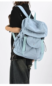 Vista laterale di uno zaino in nylon azzurro con tasche multiple indossato
