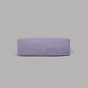 Detail of purple nylon tote bag showing wrinkled fabric texture and reinforced vertical stitching