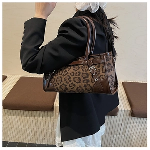 Détail du sac léopard avec garniture en cuir marron et boucle métallique réglable