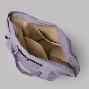 Detail showing inner nylon lining, pockets and zipper of the lilac purple tote bag
