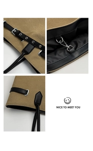 Nahaufnahme der Khaki-Canvas-Tasche mit schwarzem Lederbesatz, Ösen und verstärkten Nähten