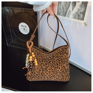 Dettaglio borsa a tracolla leopardata con frange di perline colorate e cinturino marrone