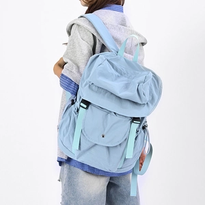 Vista laterale di uno zaino in nylon azzurro con tasche multiple e fibbie sicure