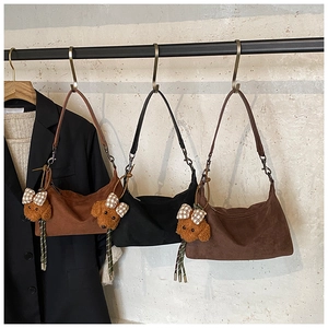 Three suede hobo bags in brown and black colors featuring cute teddy dog plush charms