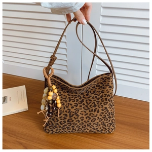 Dettaglio della borsa a secchiello leopardata con ciondolo decorativo in perle di legno