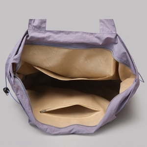 Detail view of large tote bag interior showing lavender nylon fabric and inner pockets