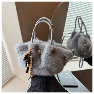 Detailaufnahme der grauen Webpelz-Handtasche mit Holzperlen-Quaste und Ledergriff