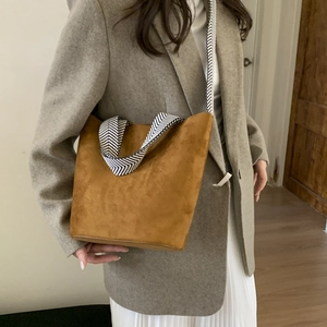 Brown faux suede bucket bag with stylish black and white herringbone woven strap detail