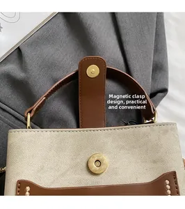 Close-up of retro magnetic clasp on canvas and brown leather bucket handbag