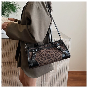Detail der Handtasche mit Leopardenmuster, schwarzen Lederbesätzen und Metallschnallen