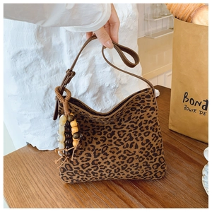 Dettaglio della borsa a secchiello leopardata con tracolla marrone e nappa di perline
