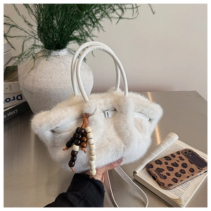Detailansicht der weißen Plüschhandtasche aus Kunstpelz mit Holzperlen und Trageriemen