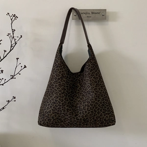 Detailopname van de retro luipaardprint tote bag met bruine leren schouderbanden
