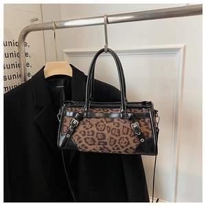 Detailansicht der Handtasche mit Leopardenmuster, Lederbesatz und Metallschnallen