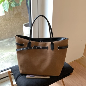 Nahaufnahme braune Canvas-Tasche mit schwarzen Ledergriffen und Metallschnallen-Detail