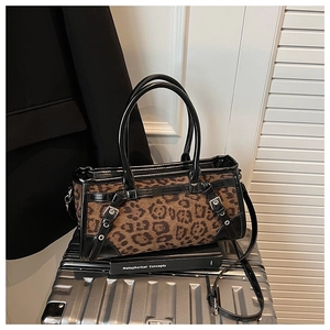 Detailansicht der Handtasche mit Leopardenmuster und schwarzen Lederakzenten im Fokus
