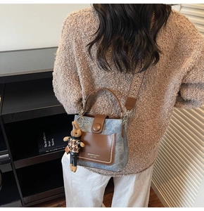 Detail of grey-blue bucket bag with vintage leather trim and ethnic wide shoulder strap