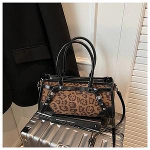 Detailansicht der Handtasche mit Leopardenmuster, schwarzen Griffen und Schnallen
