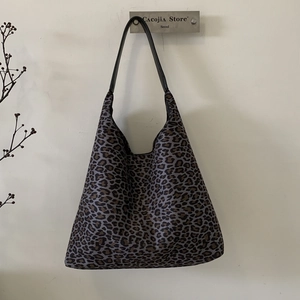 Detailopname van luipaardprint shopper met zwarte brede riem op een display