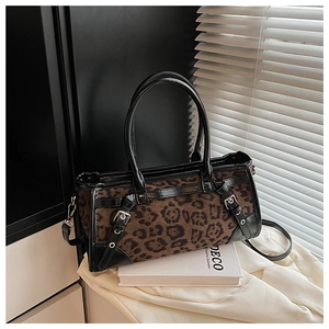 Detail der Handtasche mit Leopardenmuster, schwarzen Lederriemen und Metallschnallen
