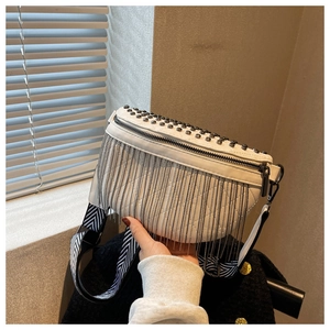 Gros plan détaillé du sac bandoulière blanc avec clous argentés, franges et sangle