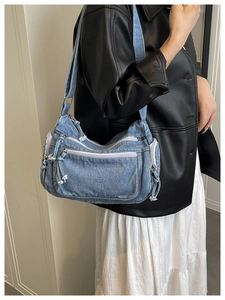 Close-up of the vintage washed denim shoulder bag showing distressed texture and zipper detail