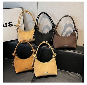 Detailed close-up of suede hobo bags in five classic colors on a premium sofa