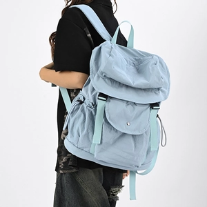 Vista laterale di uno zainetto in nylon azzurro con spalline regolabili sul modello