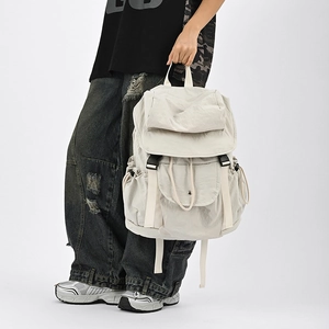 Dettaglio di uno zaino tattico in nylon beige con fibbie regolabili e tasche laterali