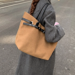Straßenszene einer großen braunen Canvas-Einkaufstasche mit schwarzen Leder-Schnallen