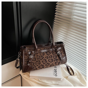 Detail einer Vintage Handtasche mit Leopardenmuster auf einem Art Deco Buch bei Tageslicht