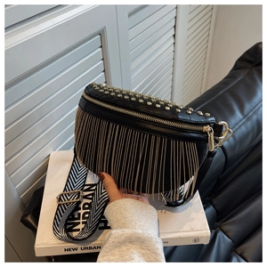 Détail du sac ceinture noir à rivets avec franges de chaînes dorées et bandoulière