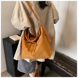 Vue détaillée du sac hobo en daim marron avec nœud de serrage et bandoulière réglable