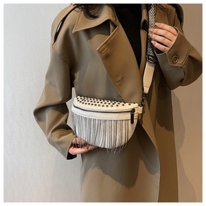 Détail d'un sac de poitrine en PU blanc avec clous métalliques, franges et bandoulière