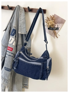 Detail of vintage denim crossbody bag with multi-pocket design and adjustable strap
