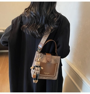Detail of vintage bucket bag with rivet pockets and geometric woven shoulder strap