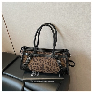 Details einer Handtasche mit Leopardenmuster und Metallschnallen auf einem Vintage-Buch