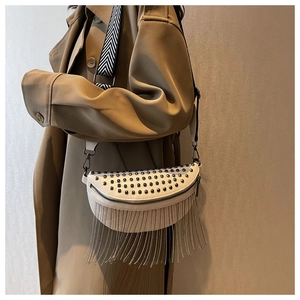 Détail du sac bandoulière blanc avec rivets et longues franges en chaînes métalliques