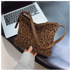 Dettaglio della borsa leopardata con trama scamosciata e sottile tracolla in pelle marrone