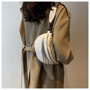 Sac banane blanc matelassé avec rivets noirs et pampilles à chaînes argentées sur modèle