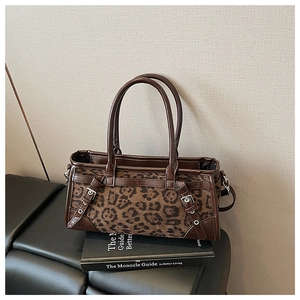 Detail einer Retro-Boston-Tasche mit Leopardenmuster und Lederbesatz auf Textur