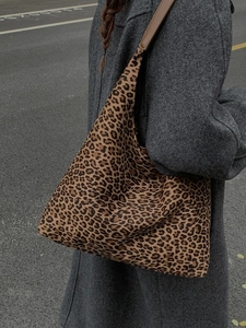 Grote shopper met luipaardprint en lederen riemen gedragen door model in de stad