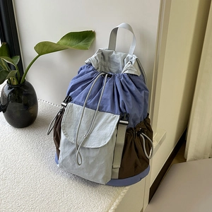 Dettaglio dello zaino a tre colori con chiusura a coulisse e tasche laterali funzionali