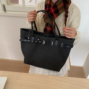Detailansicht der schwarzen Canvas-Tragetasche mit Leder-Schnalle und Metallösen-Verzierung