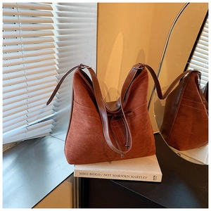 Détail du sac cabas en daim rouge rouille avec nœud et bordure en cuir lisse