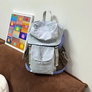 Dettaglio dello zaino in nylon bicolore con coulisse e fibbia su uno sfondo di design casa